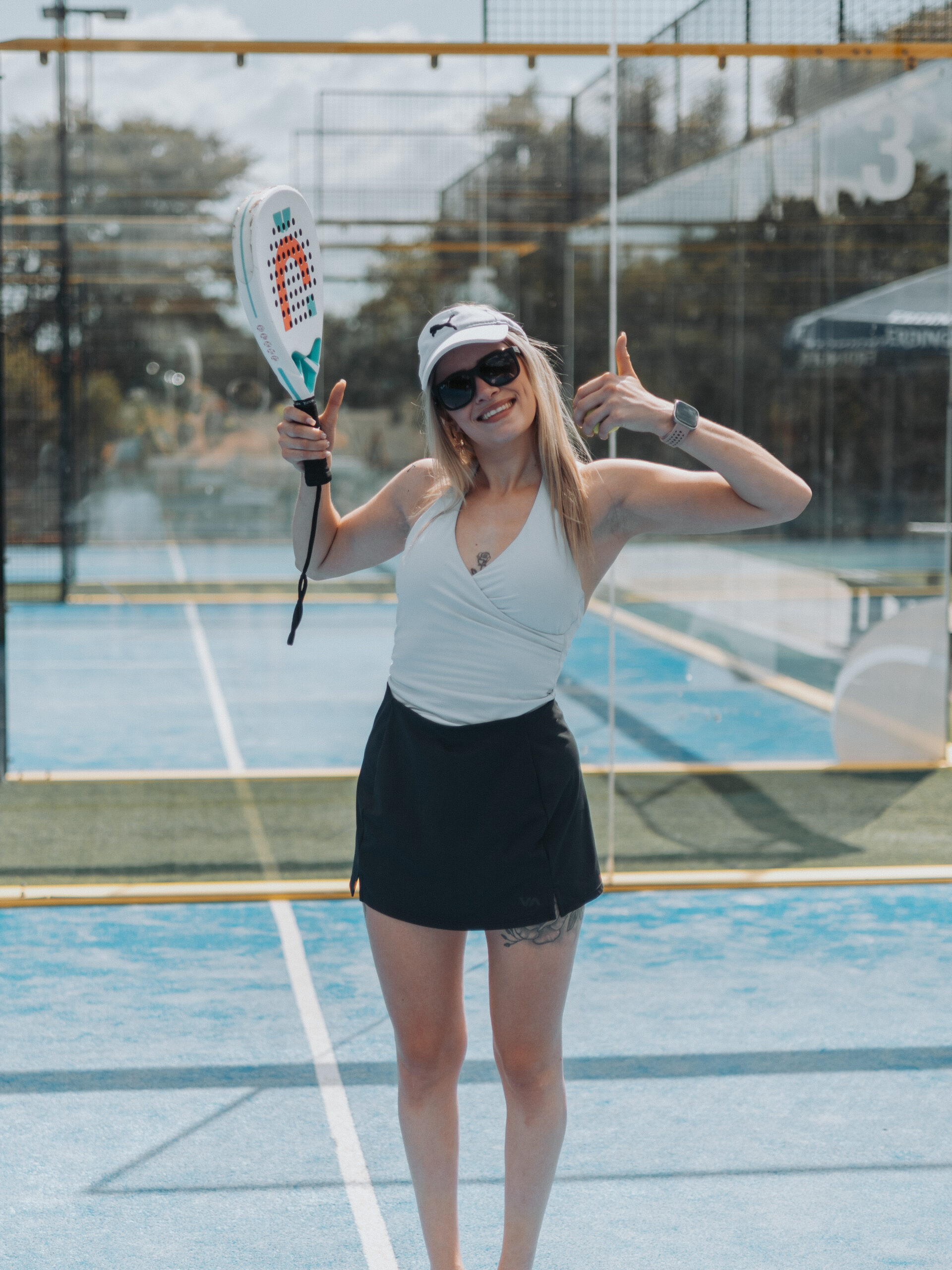 Female padel player smiling and giving thumbs up on court in Pretoria
